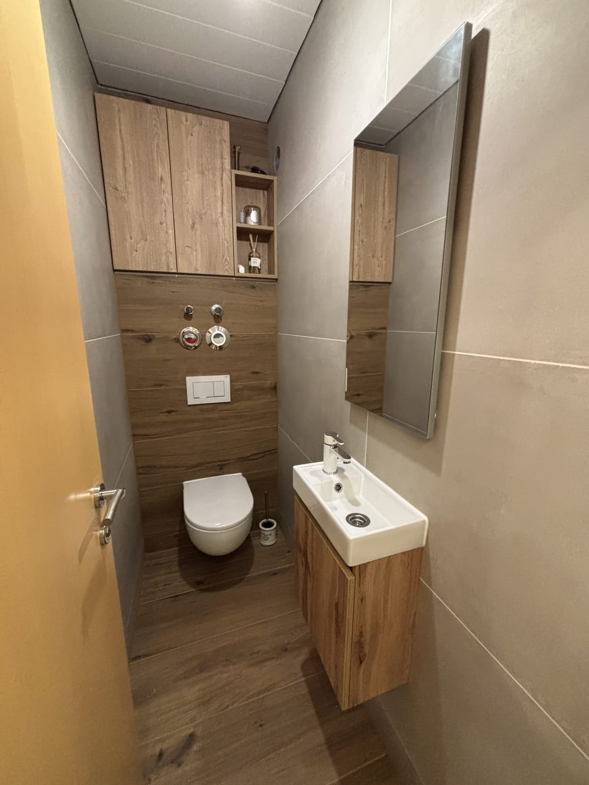 Szűk WC fahatású bordázott burkolattal, kis mosdóval és tükörrel, NM Bau, Sopron