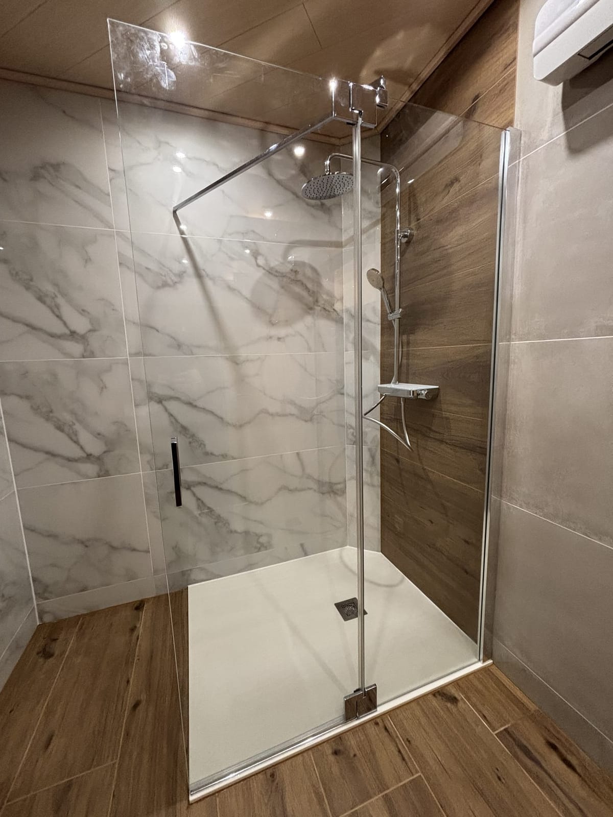 Üvegfalas walk-in zuhany fehér márvány- és fahatású burkolattal, NM Bau, Sopron